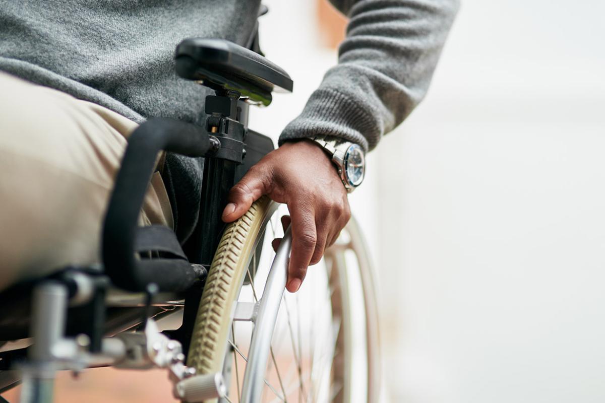 Close up of a person's hand on a wheelchair tire