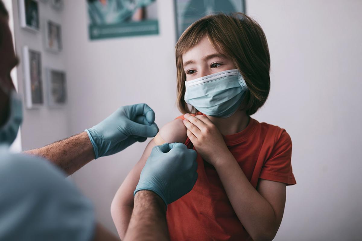Health care worker applying bandage to a child's arm
