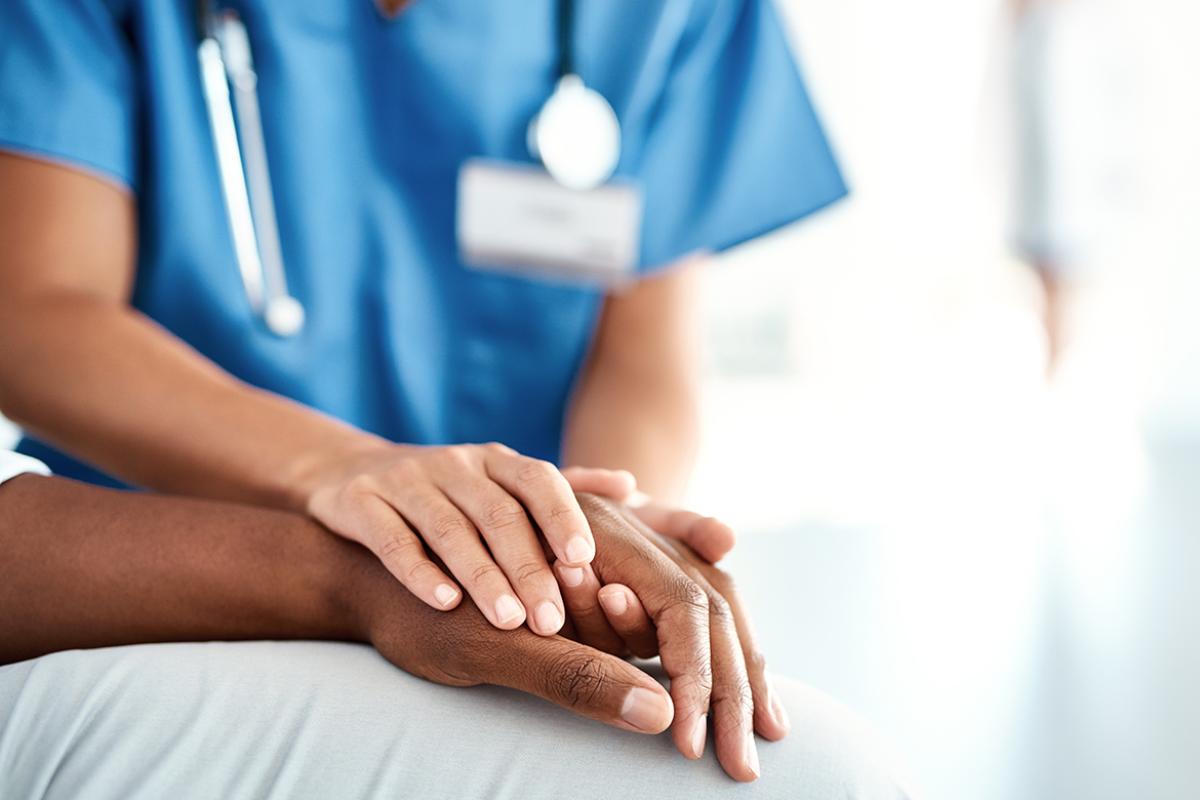 Health care worker holding patient's hand