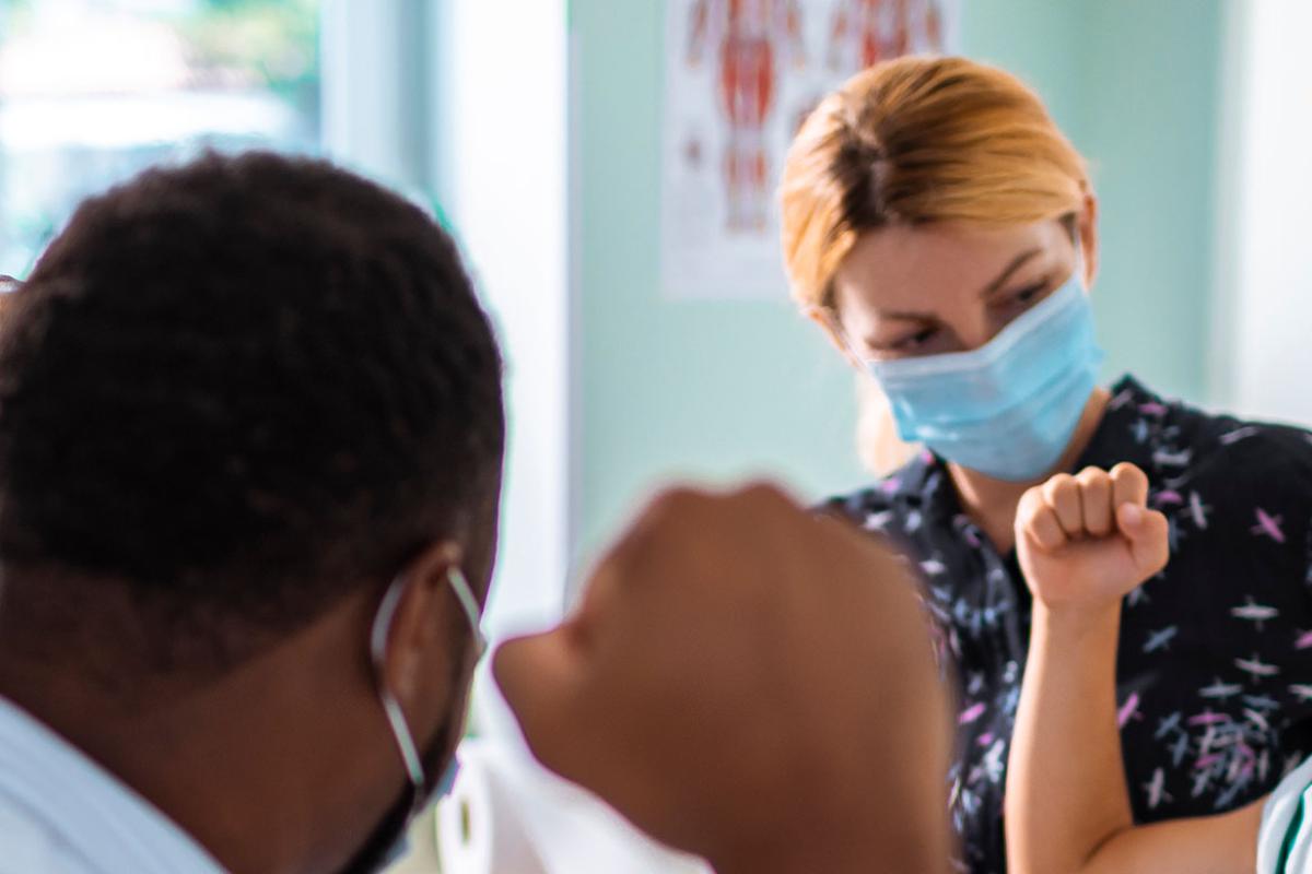 Physician and patient holding up hands in fists