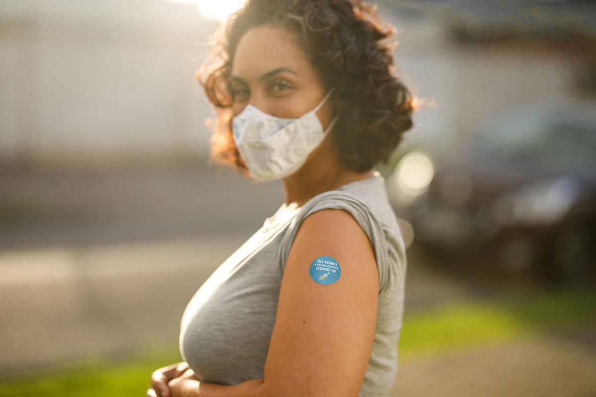 Smiling person with a bandage after receiving a vaccine