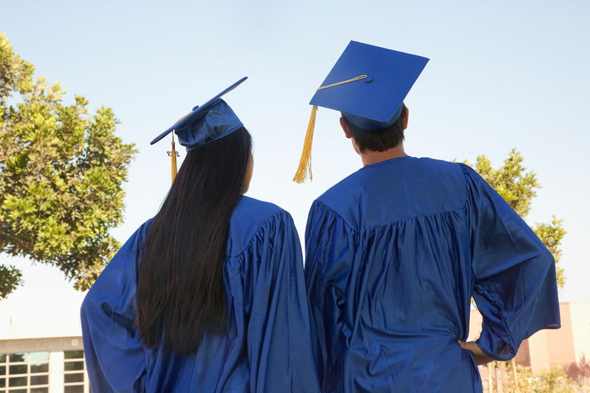 Two people wearing graduation regalia