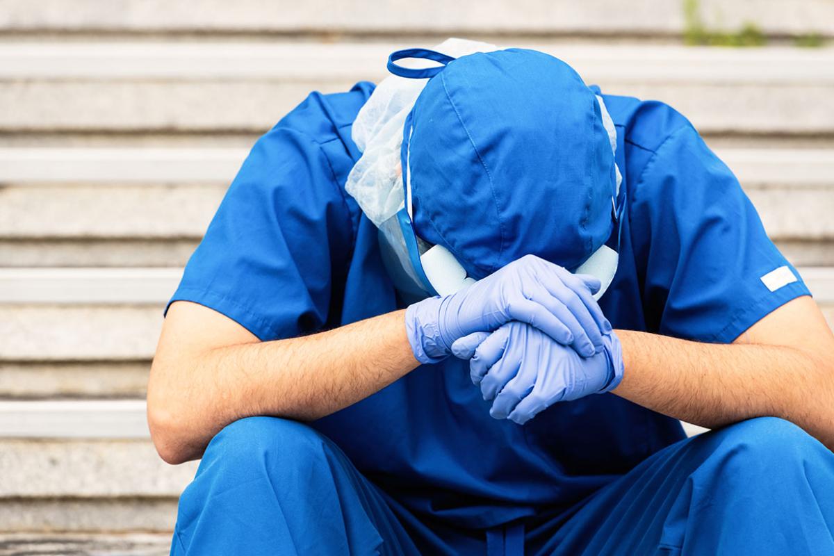 Health care worker with head in hands