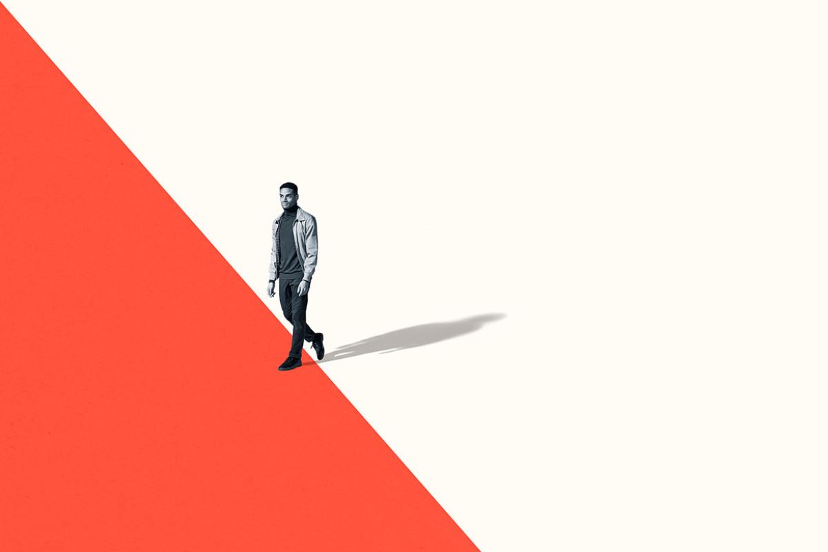 Figure of a person walking on a two-tone background