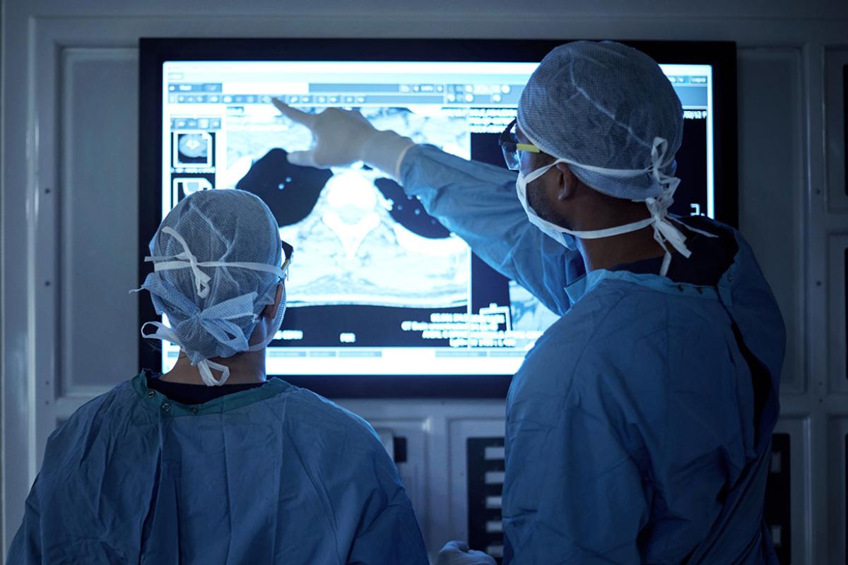 Two surgeons analyzing medical scans