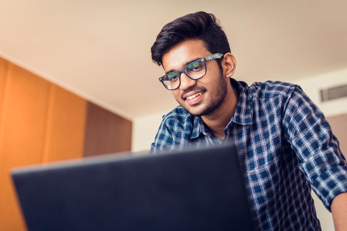 Smiling person working at a laptop