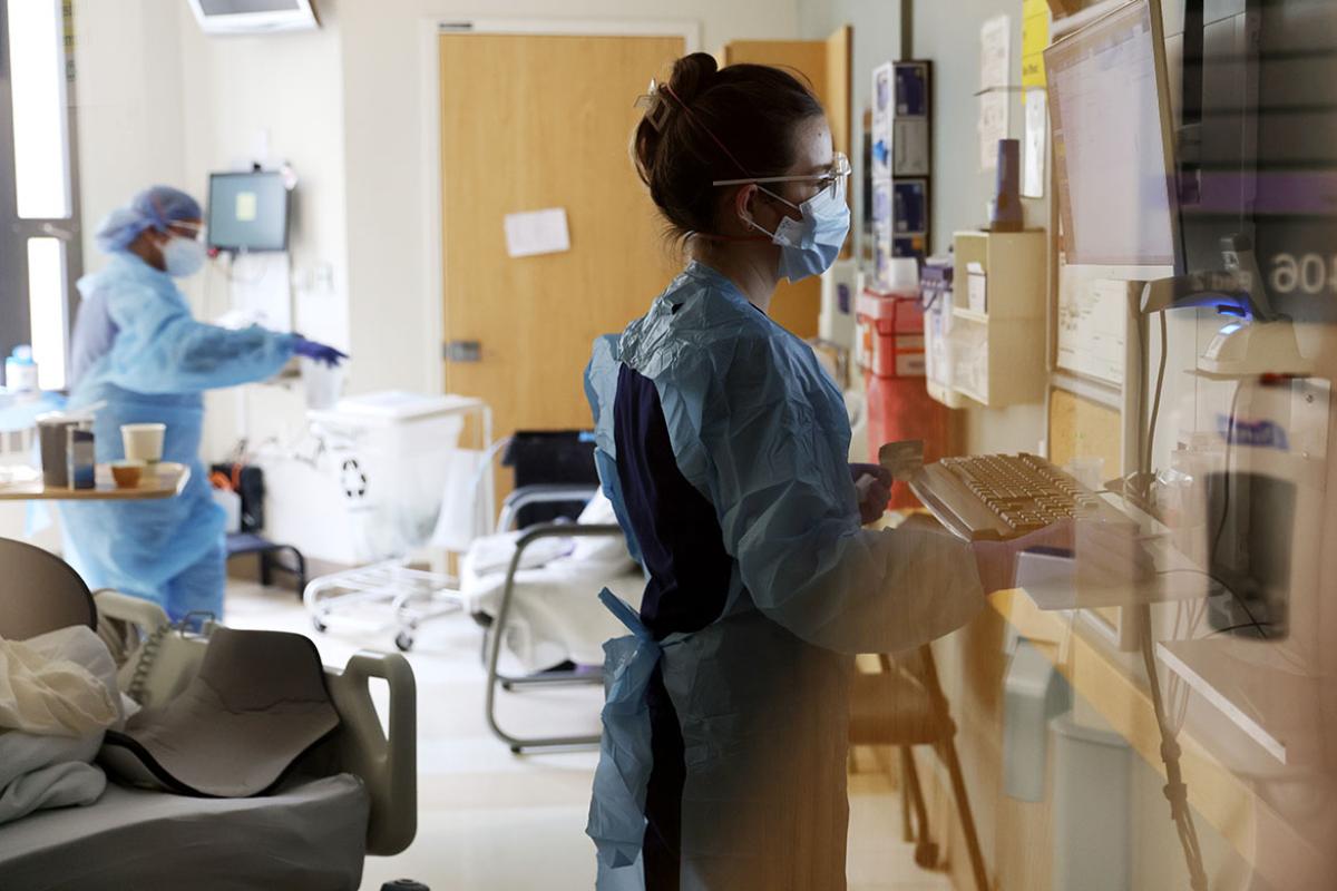 Nurse checks on a patient in the acute care COVID-19 unit