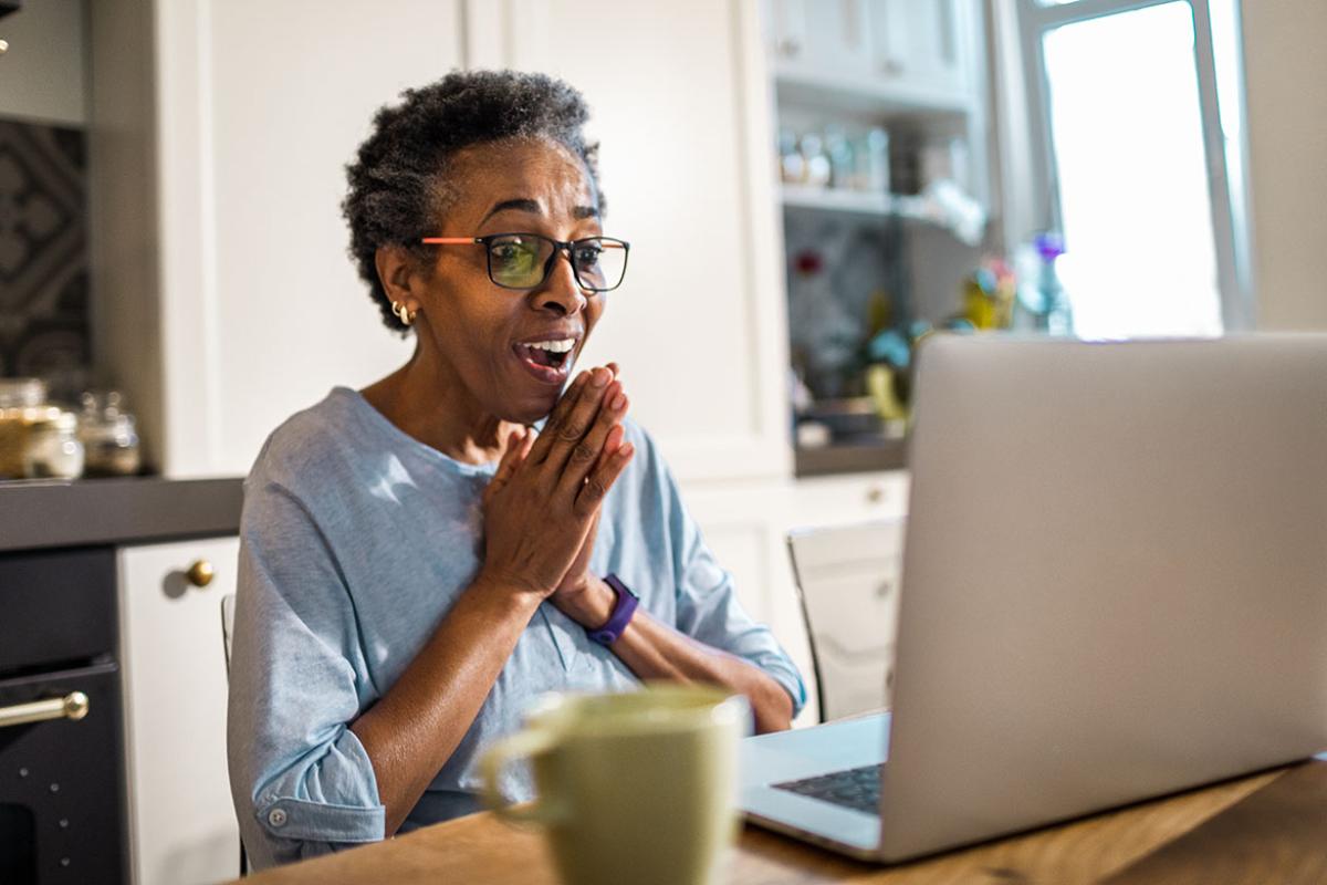 Smiling person in front of a laptop
