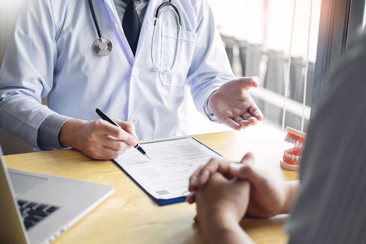 Midsection of physician in discussion with patient