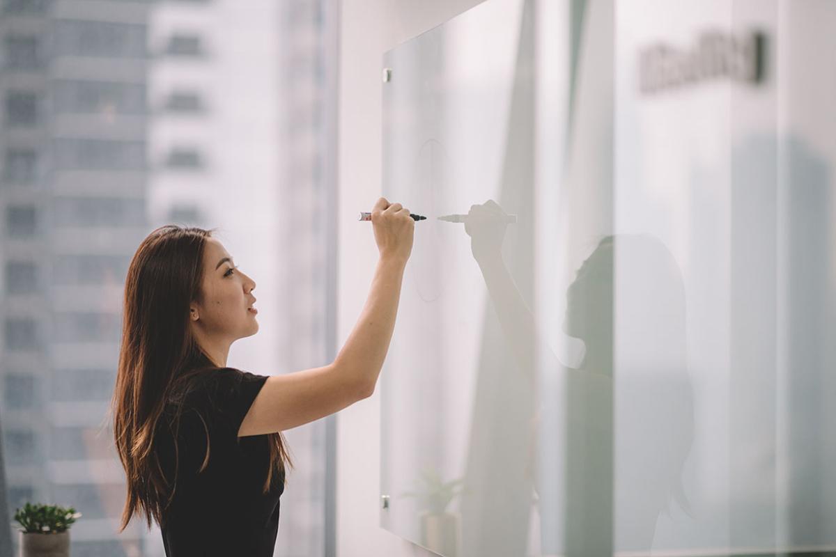 Person writing on a white board