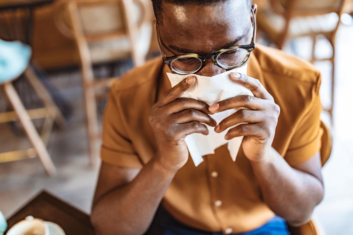 Person holding a tissue to their face