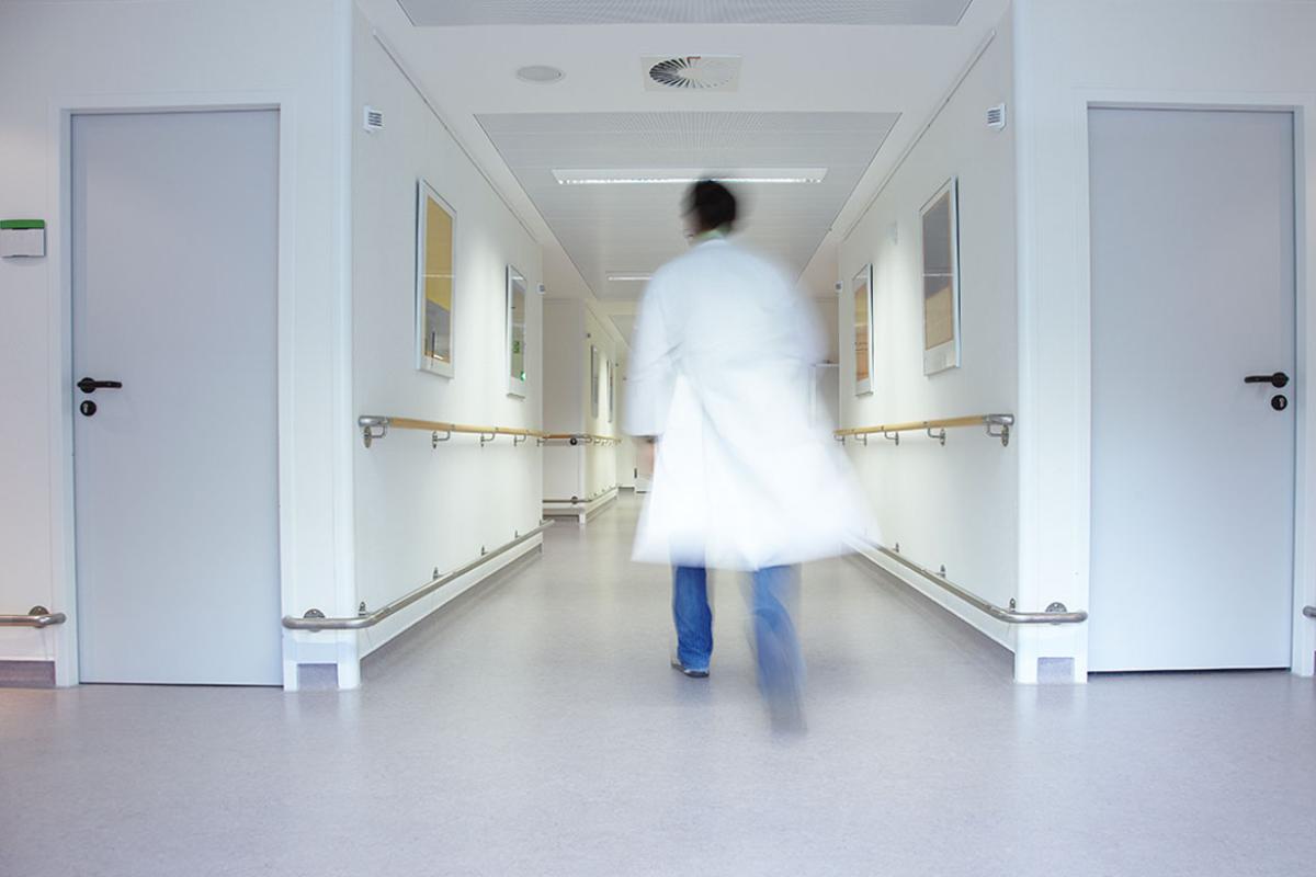 Physician walking down an empty hallway