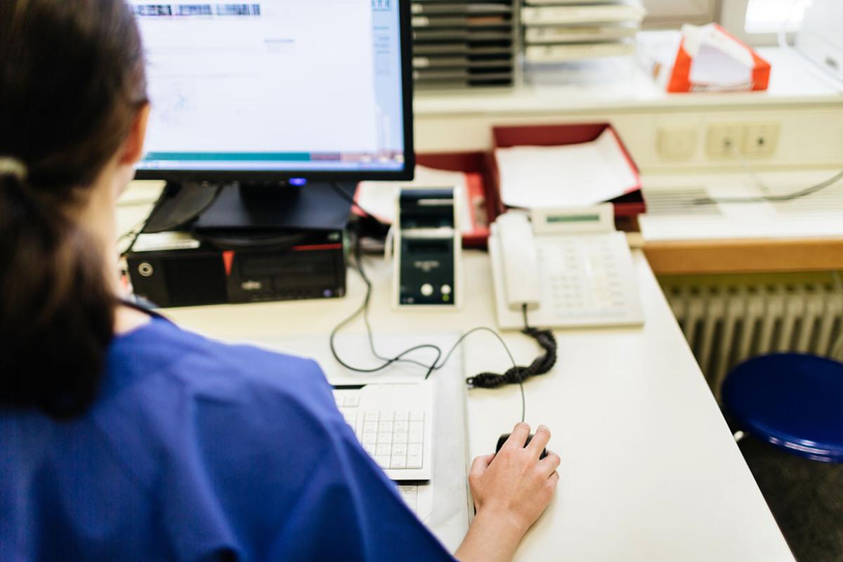 Health care professional working at a desktop computer