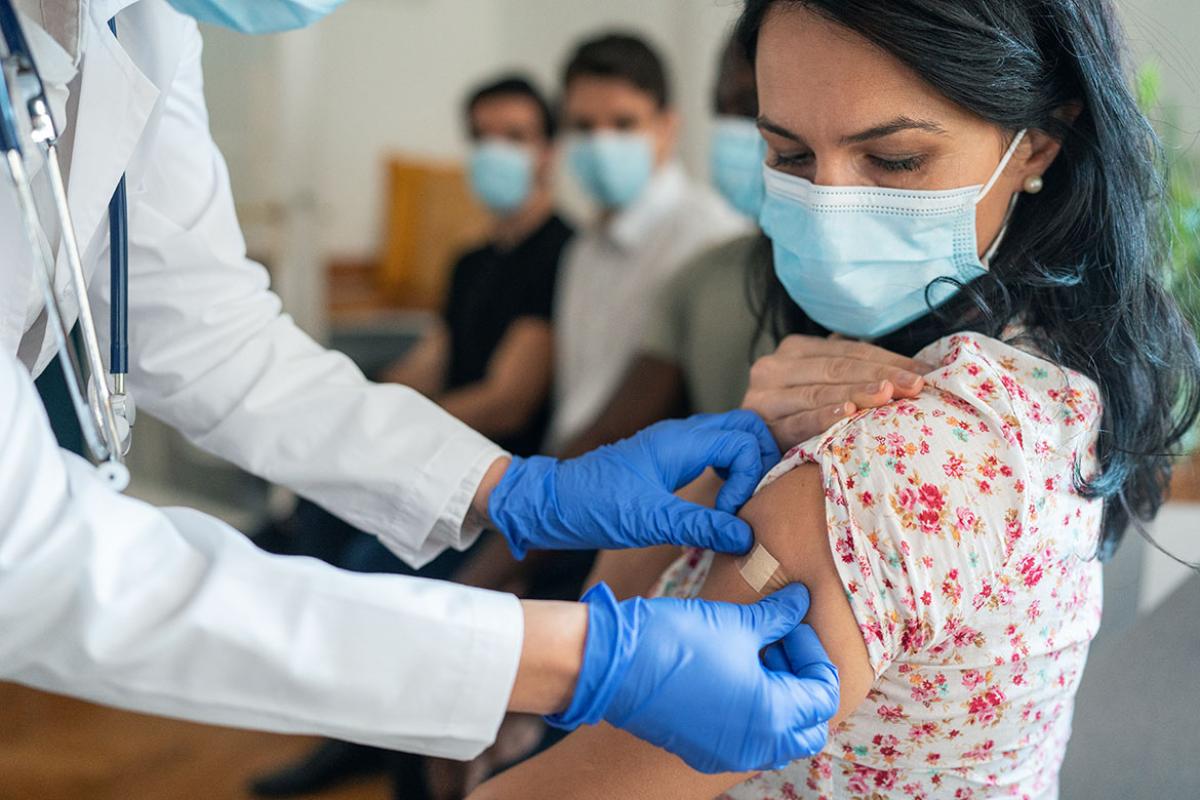 Patient looking at arm as physician applies bandage
