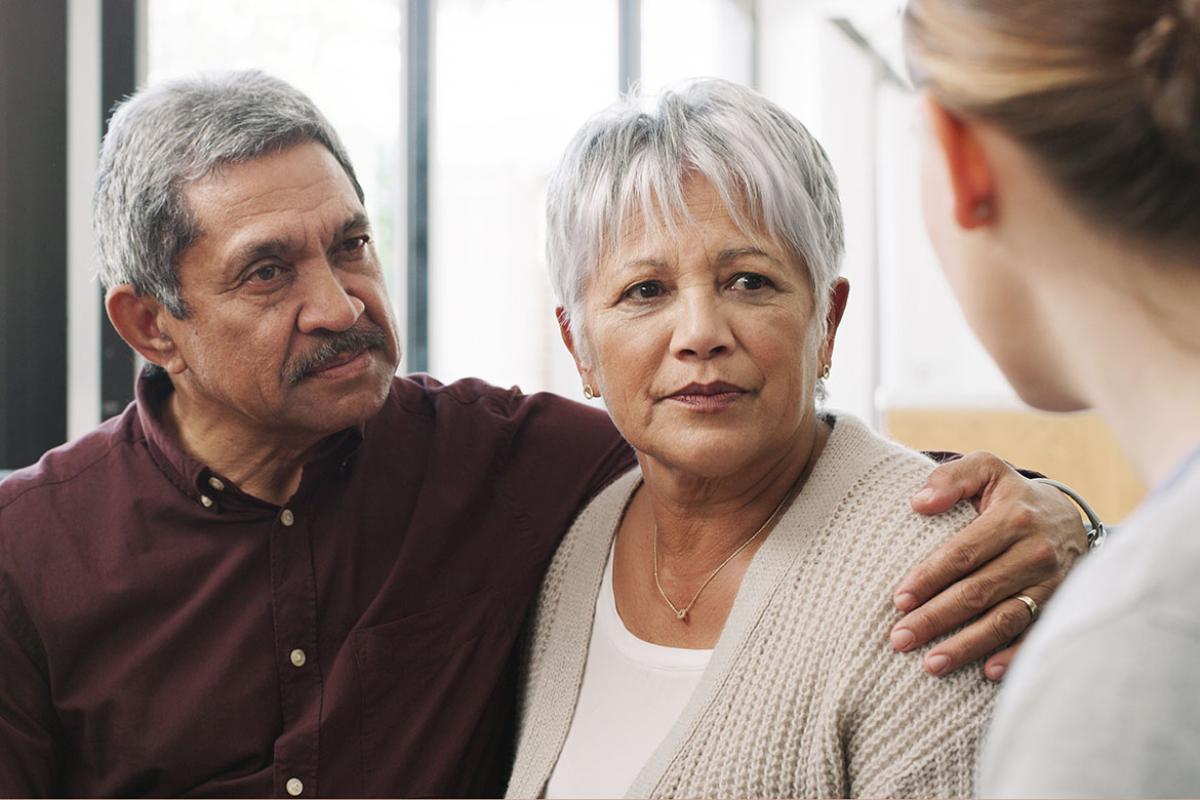 Senior couple speaking with an individual
