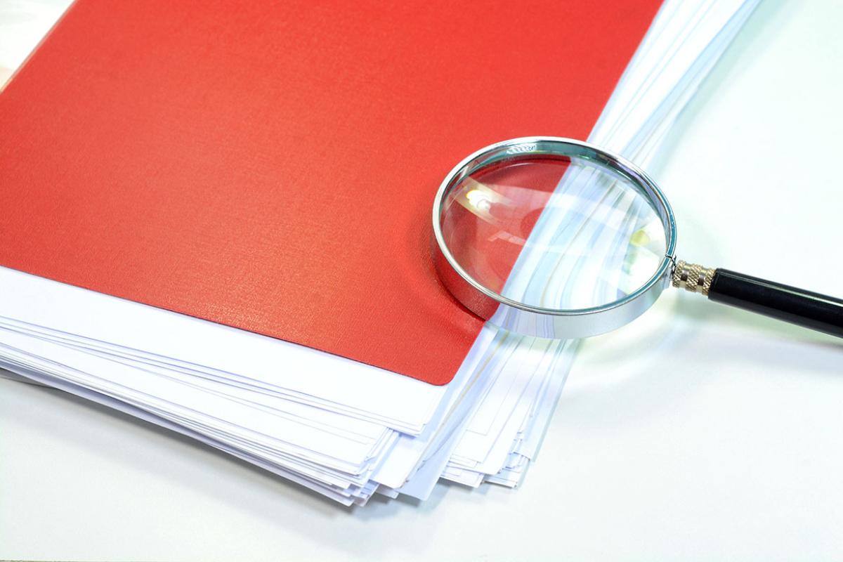 Magnifying glass on a stack of papers