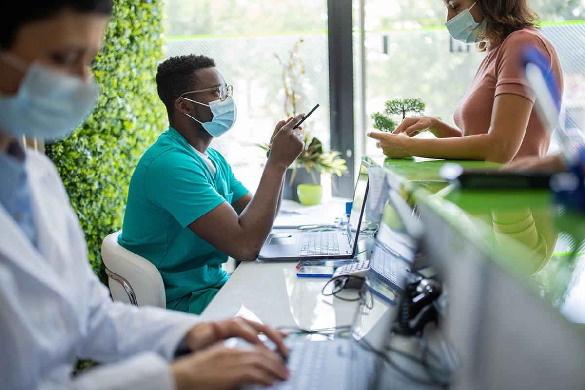 Health care workers with face masks engage patients