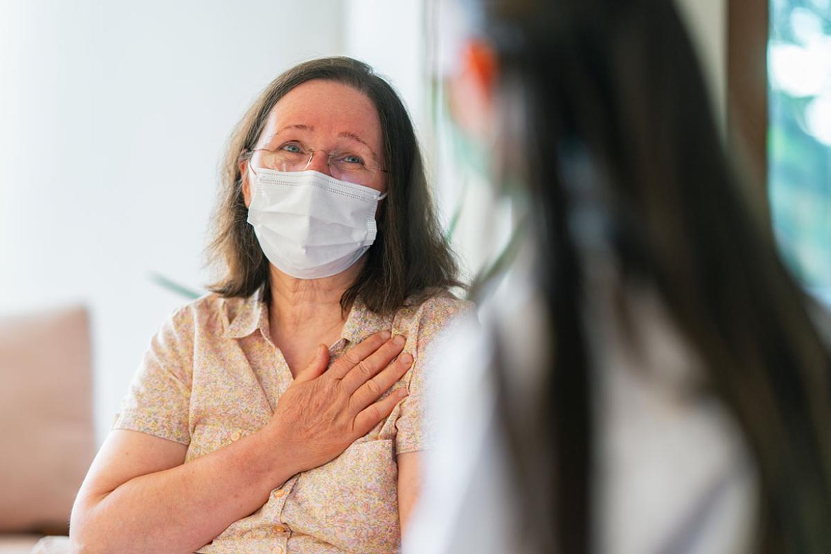 Patient with hand over her heart