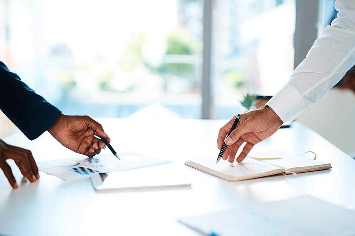 Two businesspeople going through paperwork together in a modern office