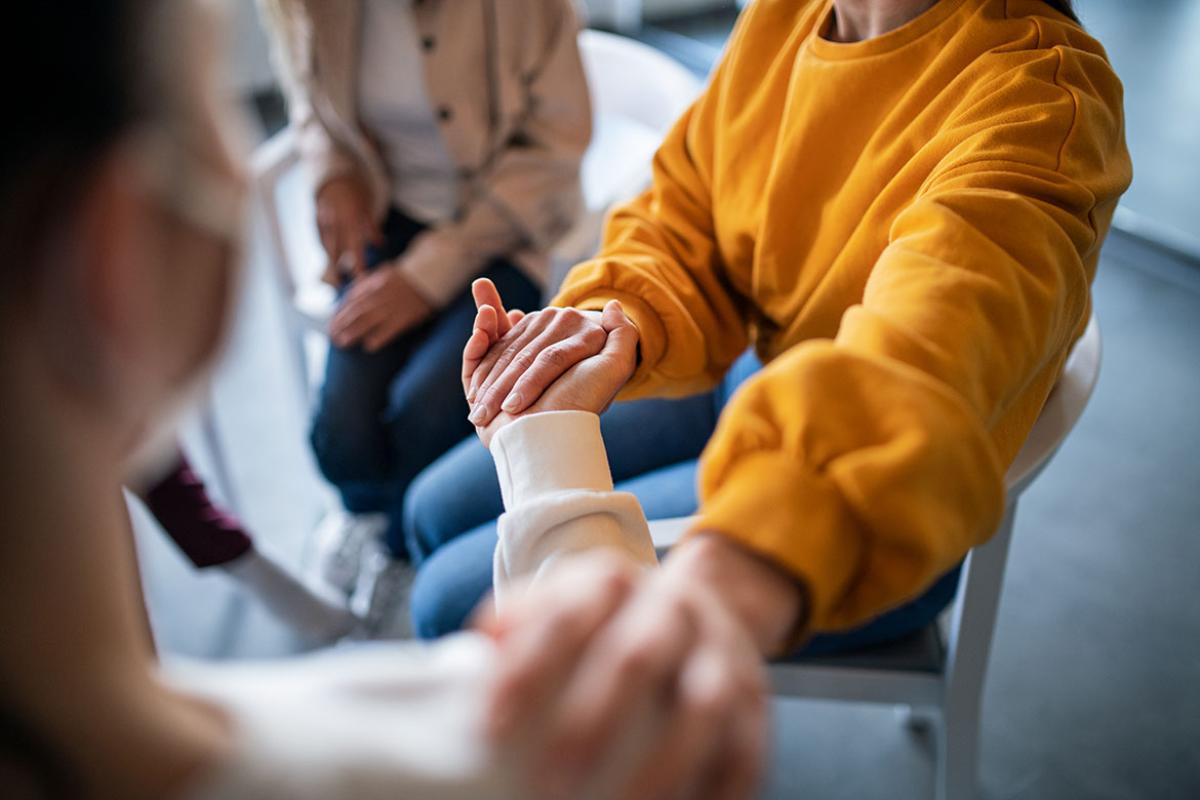 Two people holding hands in a group session