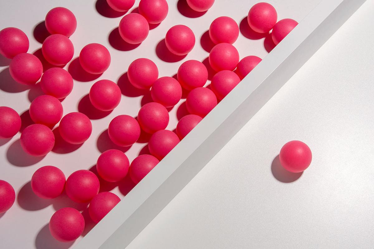 One ball on one side of dividing wall with many balls on other side