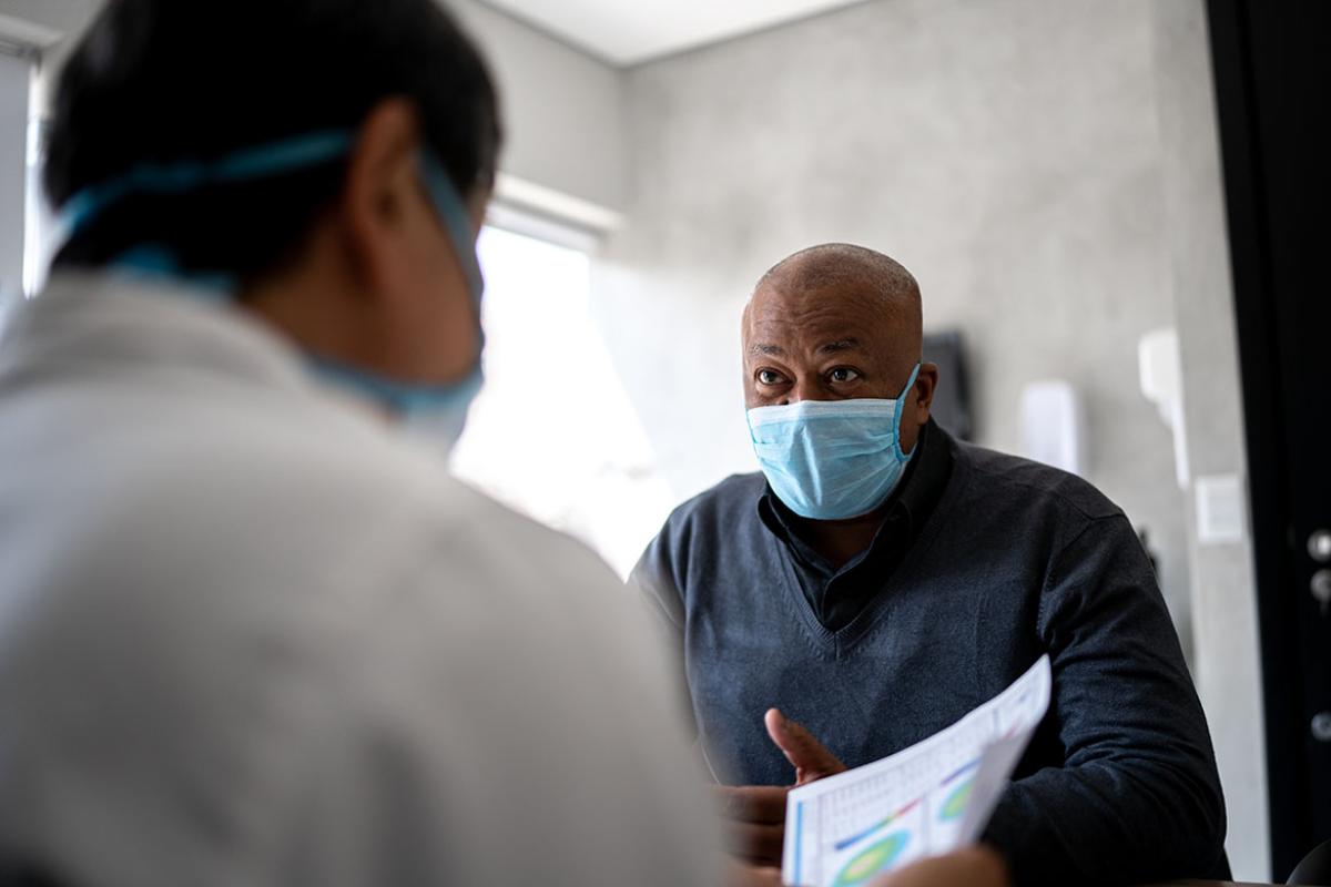 Masked patient having an appointment with a health care worker