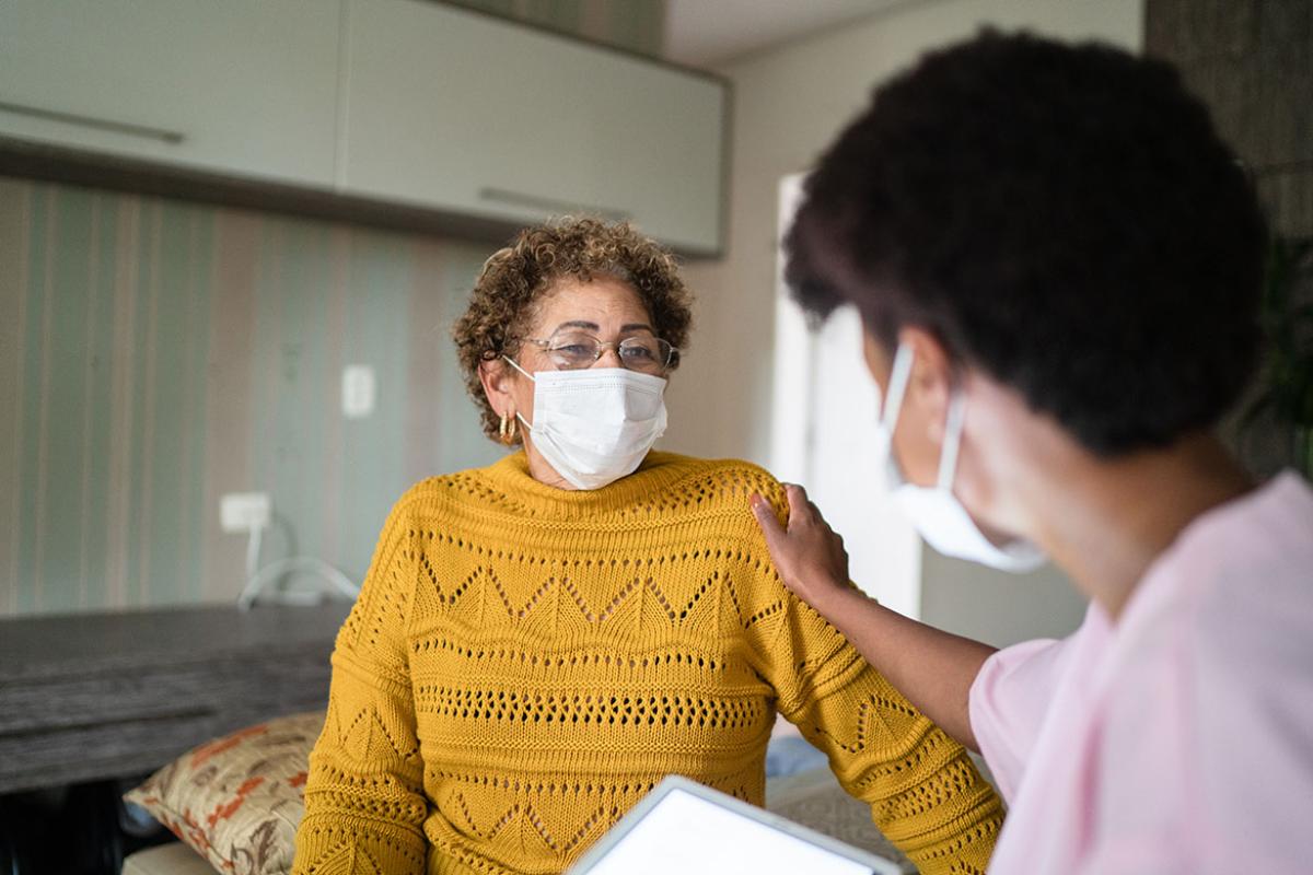 Health care worker with hand on a patient's shoulder