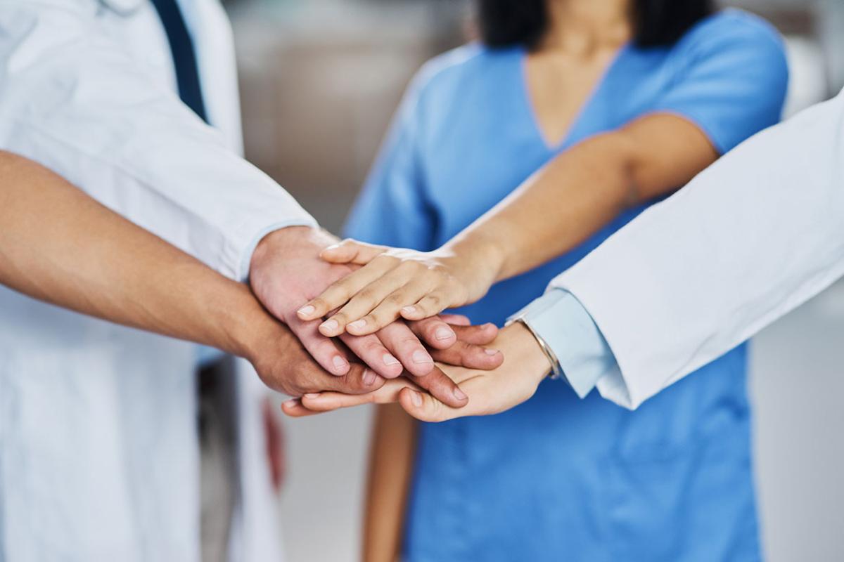 Group of health care workers stacking hands
