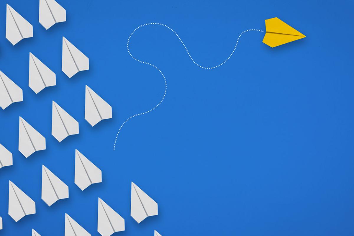 Group of paper airplanes in same direction and one airplane moving to different direction