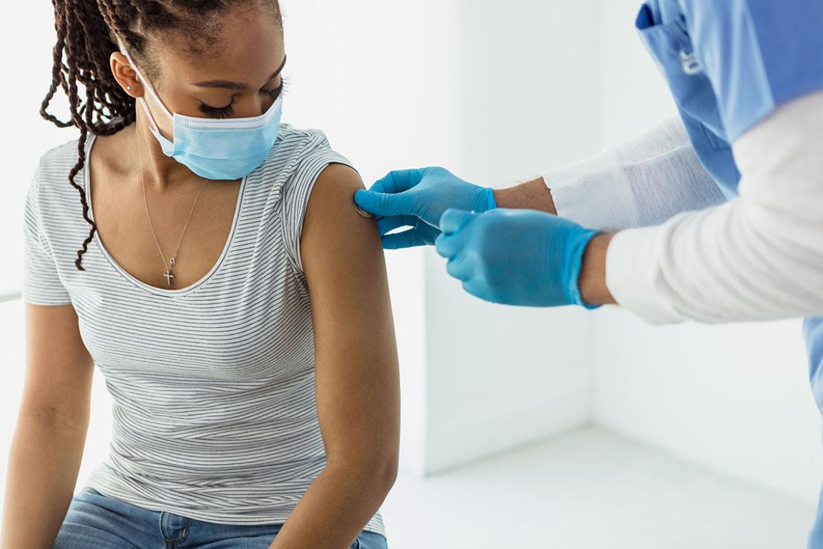 Patient looks down as nurse applies adhesive bandage