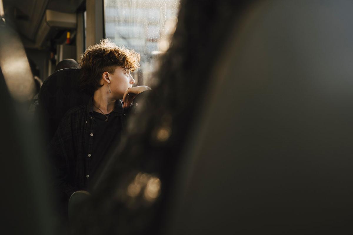 Person looking out a window, chin resting on hand