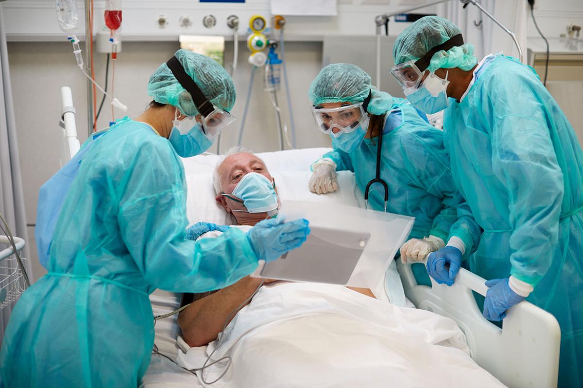 Hospital patient and health care workers looking at a tablet