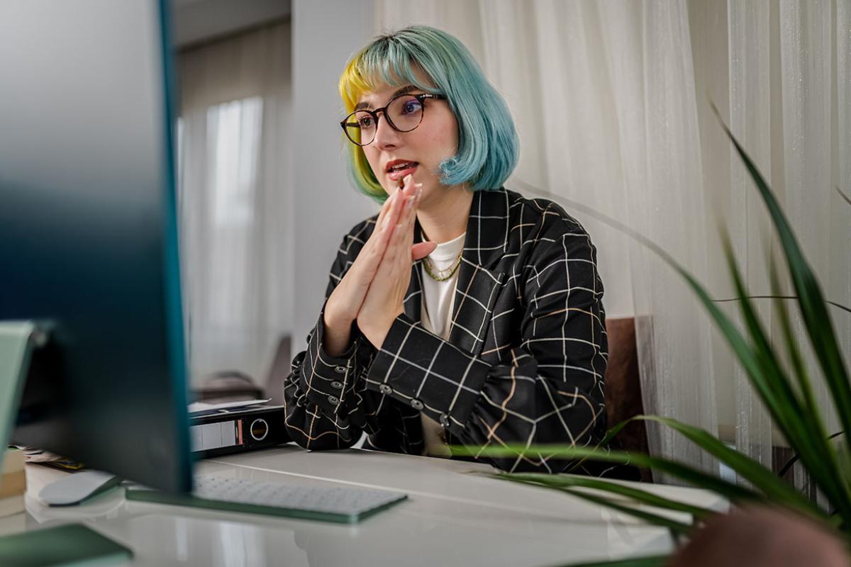 Person sitting in front of a desktop computer, having a virtual discussion