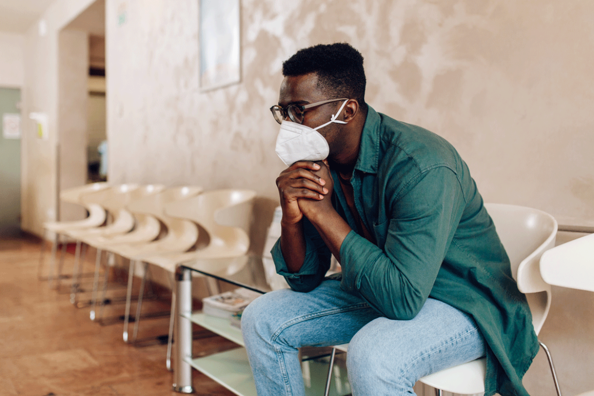 Person sitting in a waiting room, chin resting on hands