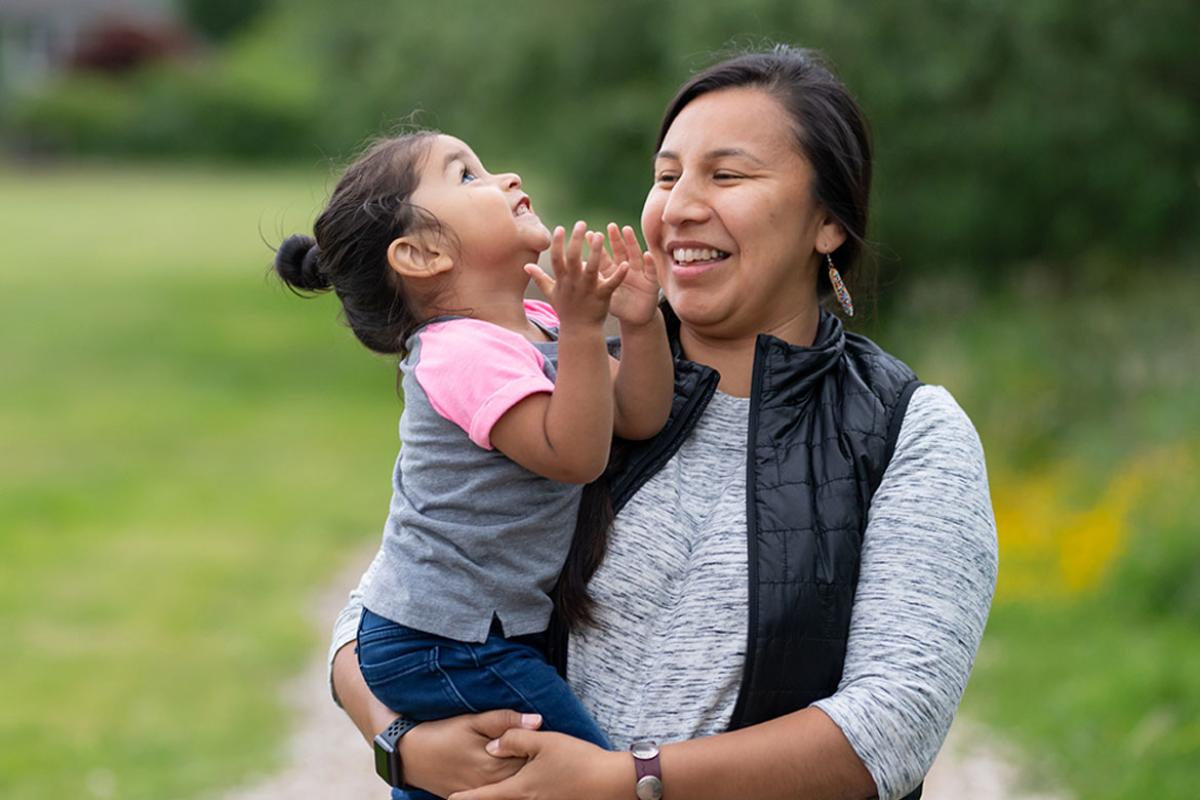 Smiling parent holding toddler