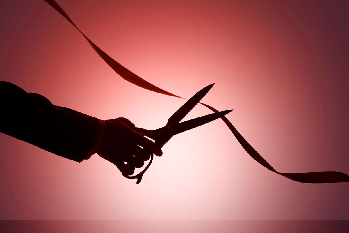 Scissors cutting red tape
