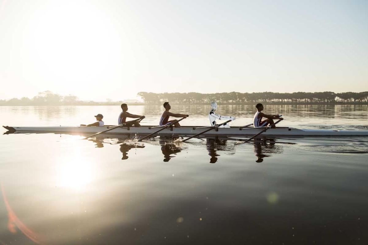 Rowing team training on a lake at dawn