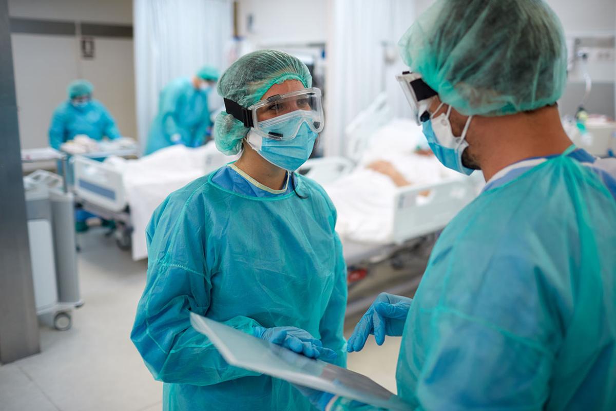 Two health care workers in PPE in discussion