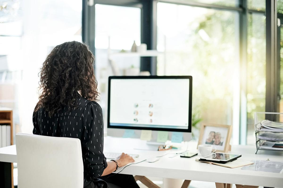 Person working at a desk, in front of a computer