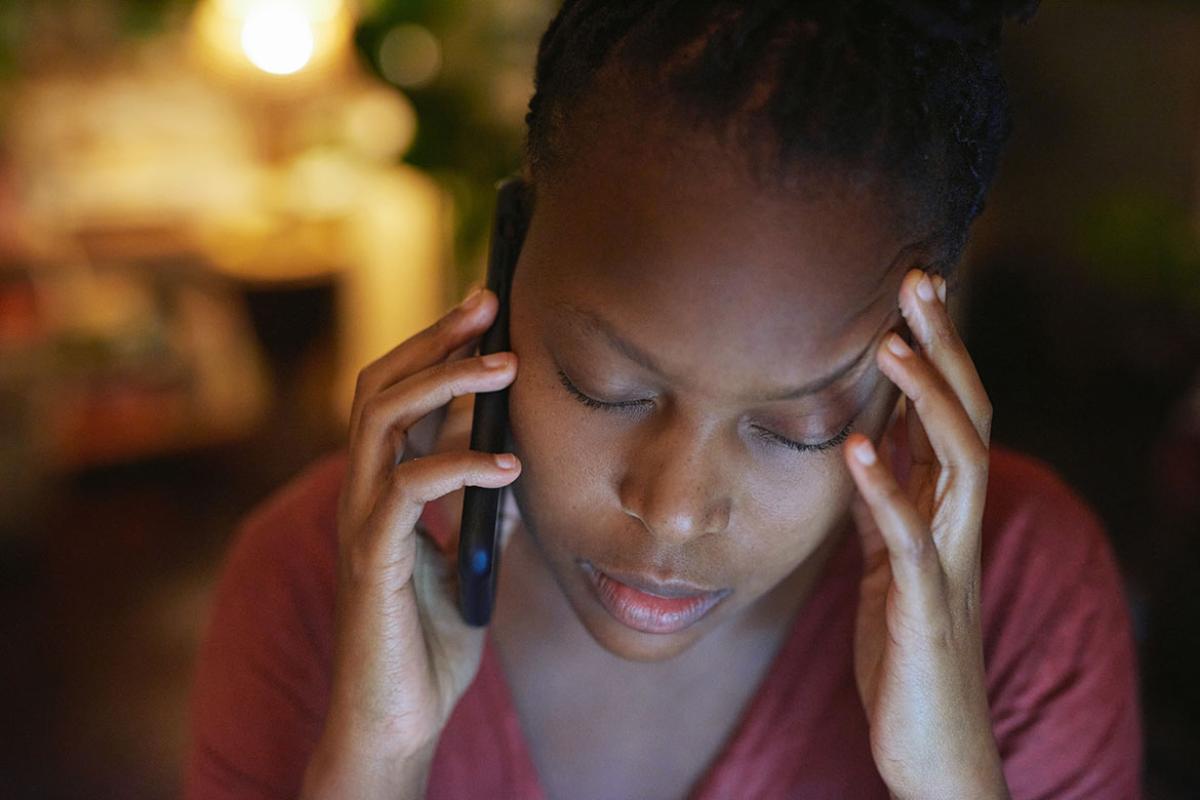 Person on phone, head in hand