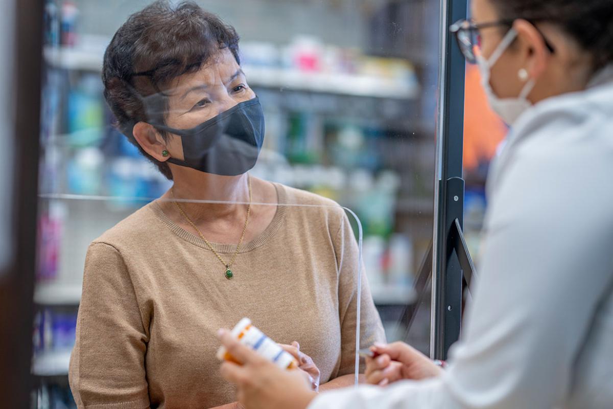 Person picking up prescription at pharmacy