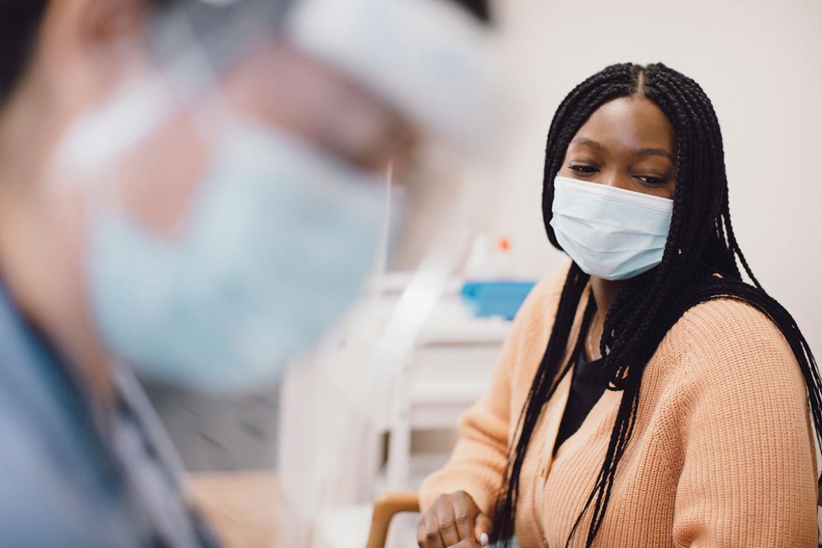 Patient in a physician's office with physician in foreground