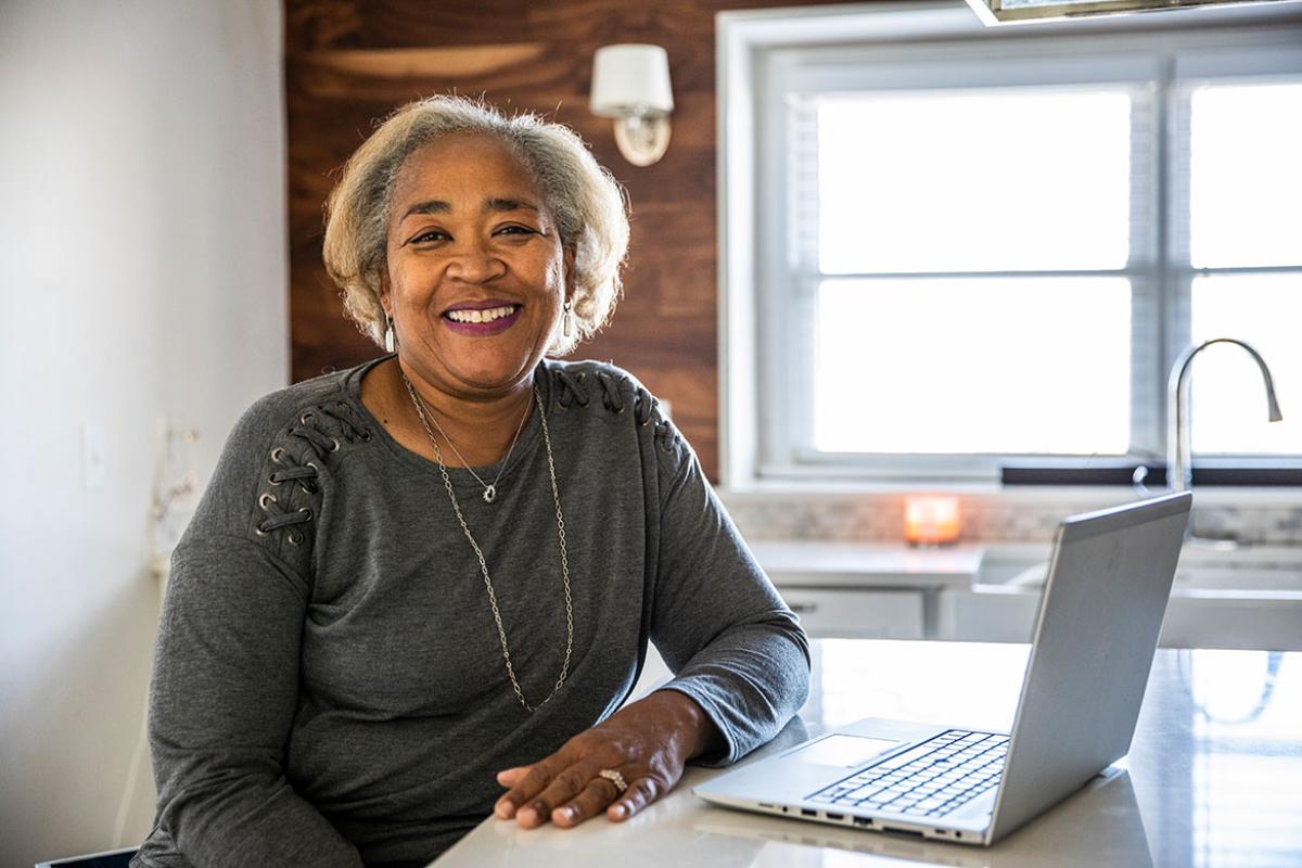 Smiling person sitting in front of laptop