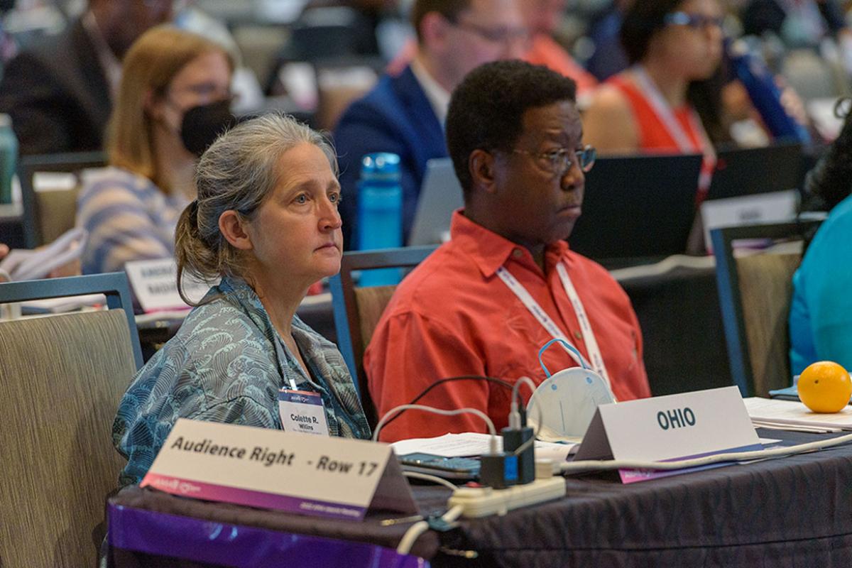 Two attendees listening at the 2022 Interim Meeting
