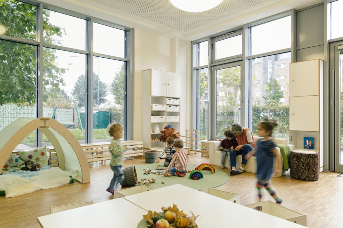 Pre-school teacher and children in playing in learning room