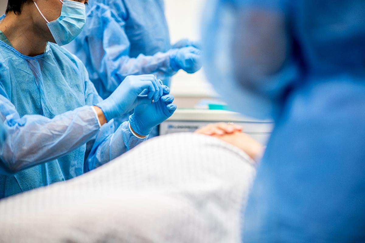 Health care workers surround a patient in a room
