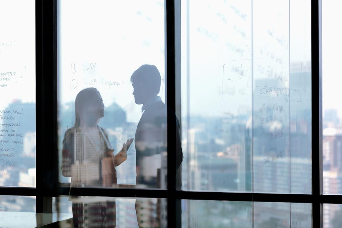 Two people speaking in a conference room