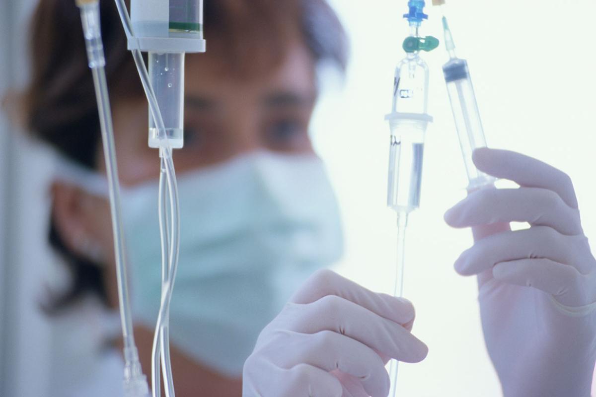 Health care worker adjusting drips