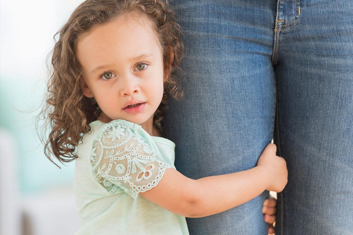 Child holding an adult's leg
