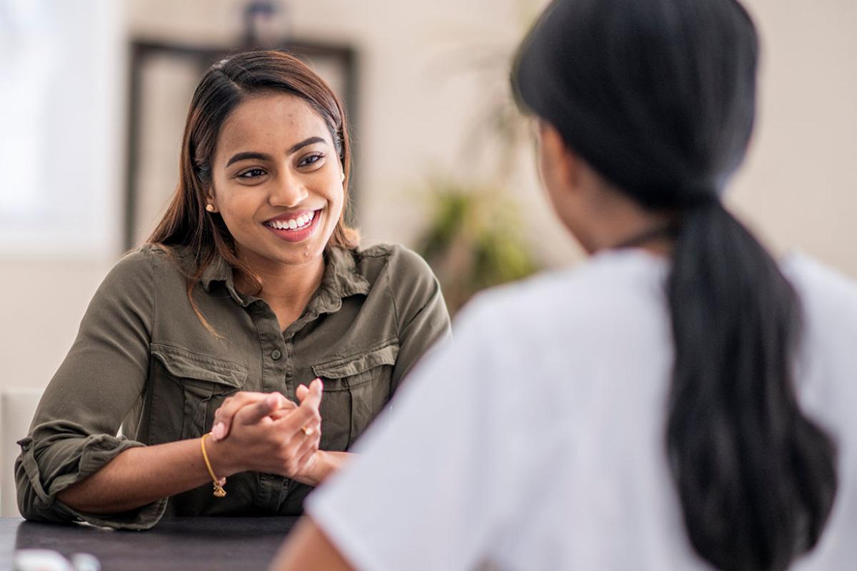 Smiling person speaking with health care worker